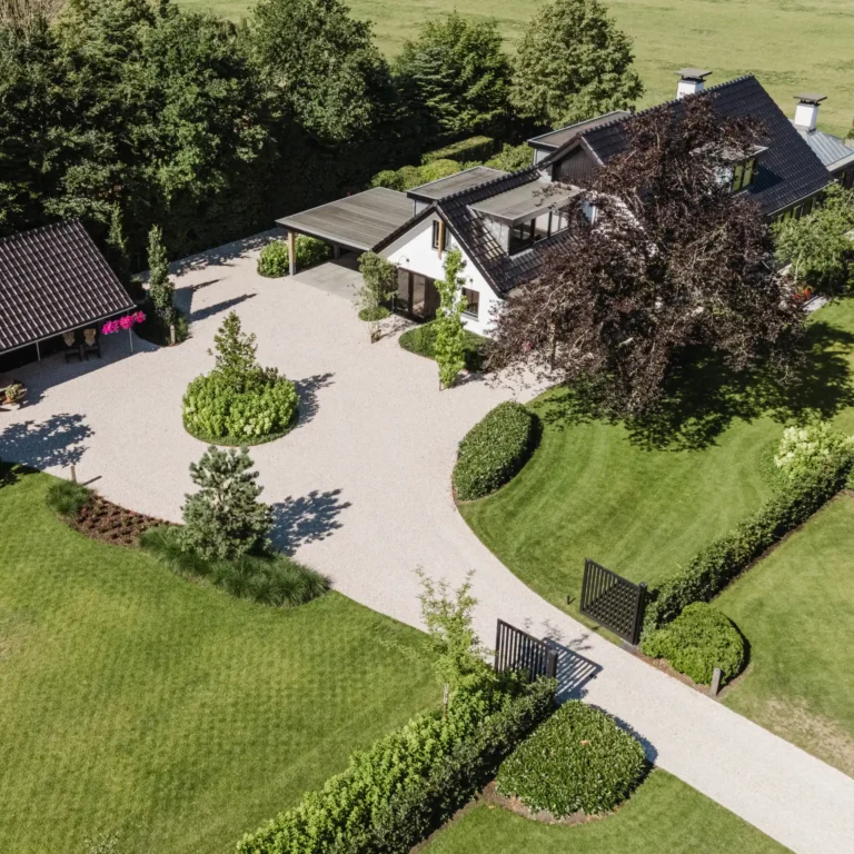 Landelijke tuin met gazon, bomen en grindpad